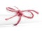 Handmade red string knot tied on white paper roll isolated