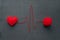 Handmade red yarn ball with heart made of red wool yarn and thread like ECG pattern on a gray woolen fabric background. Red warm