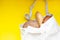 Handmade reusable cotton textile shopping bag with fresh bread on a yellow paper background.