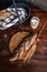 Handmade rye bread over a wooden table with spikes and cloth in a basket and a flour jar. Top view