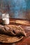 Handmade rye bread over a wooden table with spikes and a flour jar