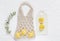 Handmade shopping macrame bag with lemon on the white cotton background