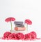 Handmade soap setting with soap bars on podium with pink flowers at white background. Front view