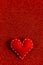 Handmade soft stitched felt heart on red shiny background, sequins in the side. The concept for Valentine's Day. Copy space