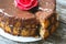 Handmade sponge cake with chocolate frosting. Small cake with cacao ganache glaze. Red sugar rose decorated. Homt pastry. Sweet