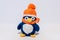 Handmade stuffed toy penguin, in orange hat.