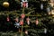 Handmade toys for Christmas tree decoration, an asterisk on green branches outdoor, toy made of wood, plaster and glitters,