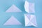 Handmade white trendy geometric polygonal paper origami on blue background. Horizontal poster.