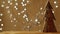 Handmade wooden Christmas tree stands on a brown background. Christmas garland sparkles in the background