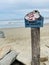 A handmade wooden sign at a beach with a message \\\'\\\'Please Don\\\'t Leave Trash It Harms The Wildlife