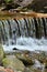 Handmade wooden water drains from small treated beams. A beautiful fragment of a small waterfall