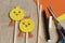 Handmade. Yellow stylized funny chickens, scissors, colored paper, wooden sticks, black felt-tip pen on rough burlap