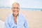 Handosme hispanic man with grey hair smiling happy at the beach, enjoying holidays on summer