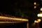 A handrail is covered in raindrops at night. Shallow focus