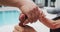 Hands of adult asian daughter holding hand of senior mother sitting in garden holding walking stick