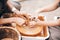 Hands of adult and child making pottery, working with wet clay closeup. Process of making bowl from clay on wheel with dirty hands