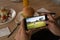 Hands of african american man at restaurant watching golf match on smartphone