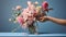 Hands arranging flowers in a vase by bright sunlight