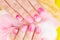 Hands with artificial manicured nails ombre gradient design in pink and white colors