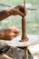 Hands of a artisan creating new clay shape from brown clay