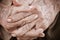 Hands Asian elderly woman grasps her hand on lap, pair of elderly wrinkled hands in prayer and Traces of hard work, World Kindness