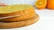 Hands of a baker cook woman with a knife cut an orange biscuit or sponge cake dough in the kitchen. Making Sweet