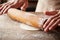 Hands baking dough with rolling pin