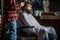 Hands of barber with hair clipper. Bearded man in barbershop. Haircut concept. Man visiting hairstylist in barbershop