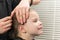 Hands of a barber straightens the hair on the client`s head