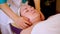 Hands beautician kneading the face of the girl lying on the couch in the Spa.