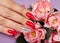 Hands with beautiful artificial manicured nails colored with red and silver nail polish