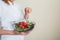 Hands of beautiful woman holding big bowl of fresh veggie salad