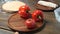 hands beautifully spread tomatoes and sweet pepper on wooden round cutting board