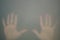 Hands behind the frosted glass. hands silhouette in the mist. loneliness concept. palm touches the glass window
