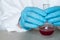 Hands of biochemist or virologist holding a flask with a blood sample in a laboratory