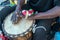 Hands of a black man playing a traditional drum.