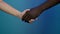 Hands of black man and white woman. Handshake close-up. Interracial friendship, anti-racism, fraternity, cooperation