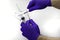 Hands in blue medical gloves hold two syringes of different diameters one of which measures the concept of drug dosage with a