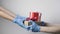 Hands in blue protective gloves giving christmas gifts with ribbons to child