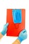 Hands with blue rubber gloves holding red folder and medical mask