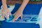 Hands of boy with blue spray paint and template letters in Hebrew on a blue T-shirt