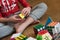 Hands of boy trying to solve the puzzle against various pyramid and cube toy puzzles background. Solving difficult tasks or stay