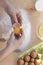 Hands break a raw egg. Stir the protein with the yolk. Sifting flour through a sieve on a wooden background. Glass bowl with mix