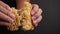 Hands breaking a crispy instant noodles in slow motion on dark background