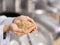 Hands of brewer holding heap of fresh malt