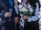 Hands of bride and groom with glasses of champagne and bouquet of bride