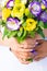 The hands of the bride and groom with wedding rings on their fingers hold together a bouquet of eustoma flowers.