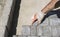 Hands of a builder in his orange gloved hands fitting laying new exterior paving stones carefully placing one in