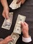 hands of business man and woman exchanging japanese banknotes and american dollars bills