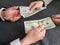 hands of business man and woman exchanging japanese banknotes and american dollars bills